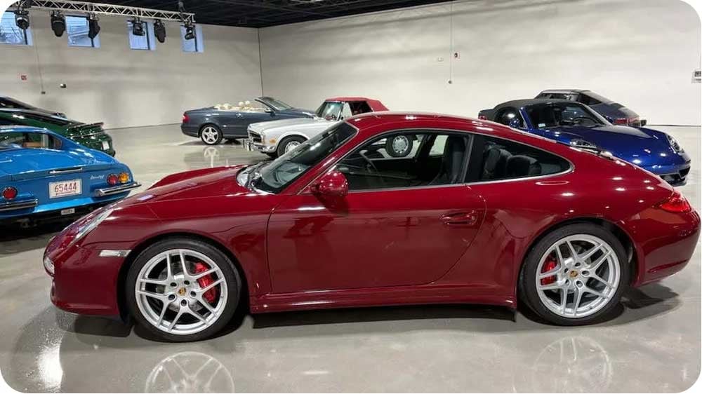 A ruby red metallic Porsche is displayed at the Archive Motor Club.