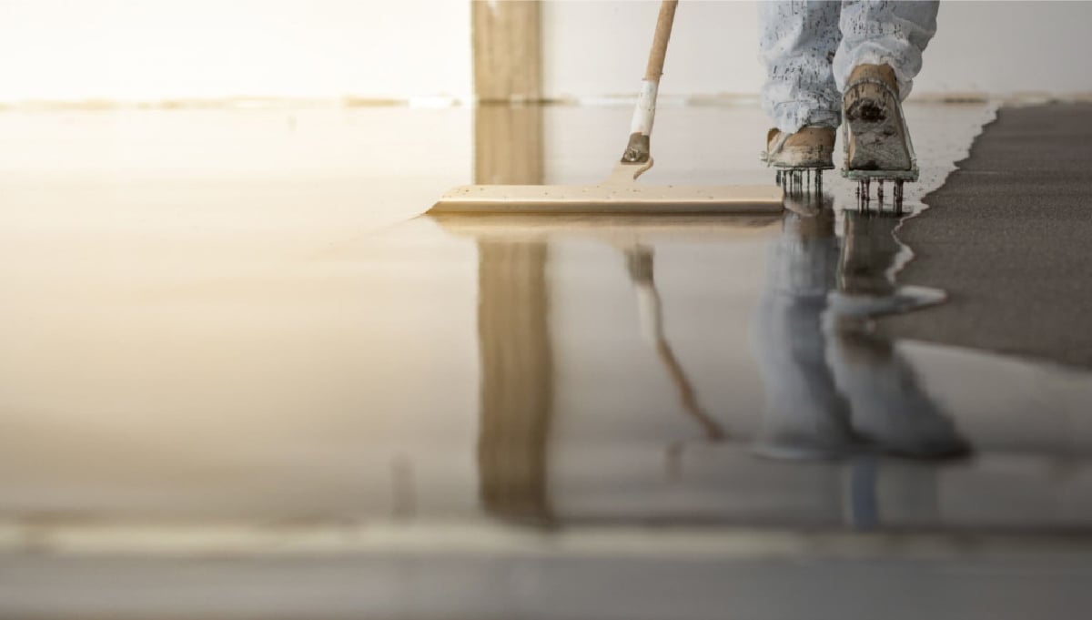 A flooring installer puts finishing touches on the topcoat of a resinous floor.